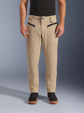 Alpinestars Flex-AST Canvas-Hose, urbane Motorradhose, Braun, Heritage-Workwear-Styling, mit schwarzen horizontalen Reißverschlusstaschen vorne und D-Ring an der Gürtelschlaufe, getragen mit schwarzem Shirt und Schuhen, Studioansicht von vorne