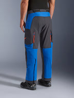 Alpinestars Maxdura Dual Hose, Königsblau und Dunkelgrau, Rückansicht mit Reißverschlusstaschen und Belüftungszonen, Überstiefel-Passform getragen mit schwarzen Alpinestars Stiefeln, strapazierfähige Adventure- und Dual-Sport-Ausrüstung