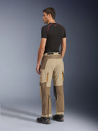 Alpinestars Maxdura Dual Hose, Adventure- und Dual-Sport-Motorradhose, Walnut Aluminum, Rückansicht getragen von einem Modell mit schwarzem Baselayer und Motorradstiefeln, mit Multi-Panel-Konstruktion, hinteren Belüftungsreißverschlüssen und verstärkten Überlagerungen.