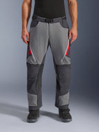 Alpinestars Maxdura Dual Hose, Adventure-Motorradhose, Dunkelgrau und Tiefgrau mit roten Akzenten, Vorderansicht mit Reißverschluss-Belüftungsöffnungen an den Oberschenkeln, Gürtel mit Magnetschnalle und verstärkten Kniepaneelen, Over-Boot-Design für Dual-Sport-Fahrten.