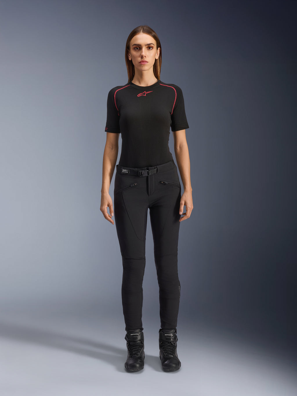 Alpinestars Alamosa Damenhose, schmal geschnittene schwarze Motorradhose, an einem Modell in der Vorderansicht gezeigt, mit Reißverschlusstaschen vorne und integriertem Taillengürtel, minimalistischer, von Streetwear inspirierter Stil für urbanes Fahren