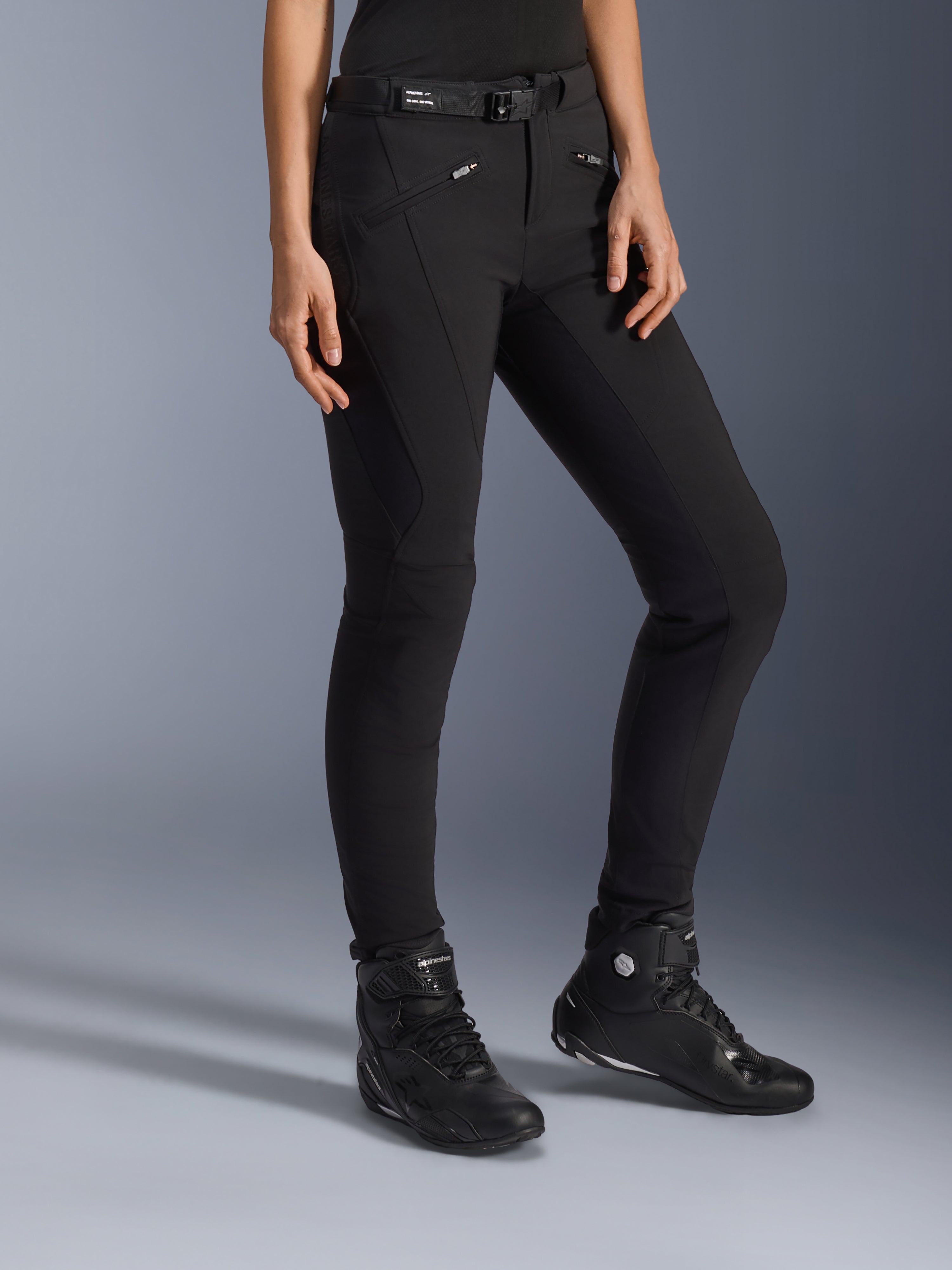 Alpinestars Alamosa Damen-Hose, Schwarze Urban-Motorradhose, Slim-Fit-Design mit Reißverschlusstaschen und integriertem Taillengürtel, kombiniert mit schwarzen High-Top-Motorradschuhen