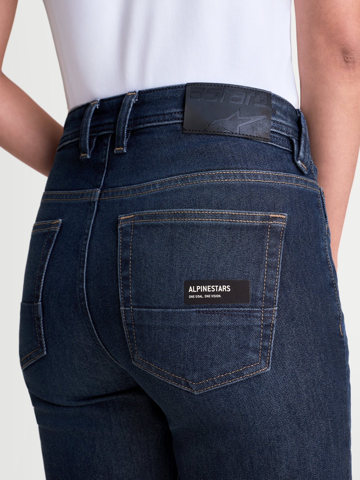 Alpinestars Stella Flex Ast 7 Denim Hose, Damen-Motorradjeans in Dunkelblau, Nahaufnahme der Rückseite mit Leder-Aufnäher, Markentasche und einlagiger technischer Denim-Konstruktion an Model
