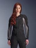 Alpinestars Stella Troop-Air Jacke für Damen, Motorrad-Meshjacke, Schwarz, Ash Gray und Pink Fluo, von einem Model mit passender Motorradhose getragen, mit belüfteter 2D-Tech-Mesh-Konstruktion und pinkfarbenem Logo-Detail, konzipiert für urbane Fahrten im Sommer.