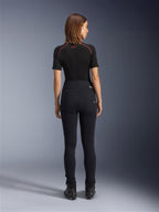 Alpinestars Stella Flex-Ast Leggings, Motorrad-Leggings für Damen, Schwarz, Rückansicht mit hoch taillierter Slim-Fit-Passform, kombiniert mit schwarzem Kurzarm-Oberteil und schwarzen Motorradstiefeln, urbane Fahrausrüstung