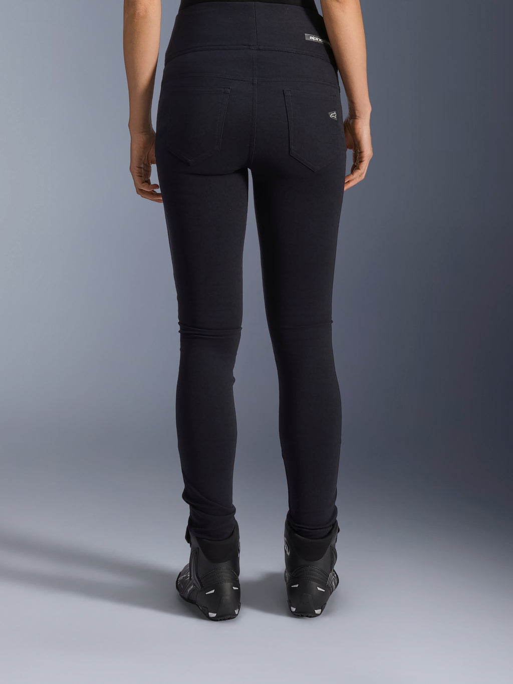 Alpinestars Stella Flex-Ast Leggings, Damen-Motorrad-Leggings, Schwarz, Rückansicht mit Gesäßtaschen und schmaler Passform, getragen mit schwarzen Motorradstiefeln, urbaner Fahrstil
