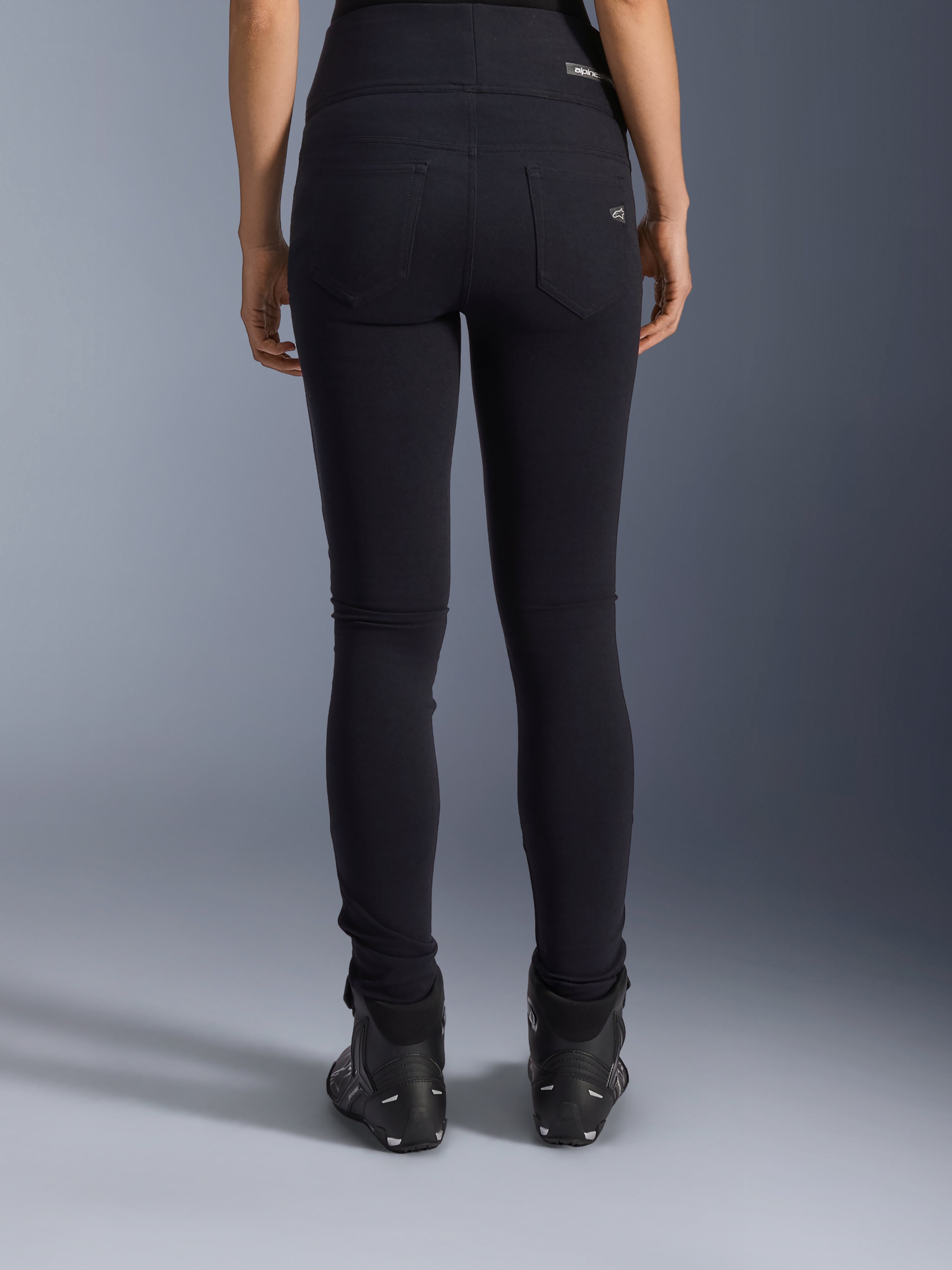 Alpinestars Stella Flex-Ast Leggings, Damen-Motorrad-Leggings, Schwarz, Rückansicht mit Gesäßtaschen und schmaler Passform, getragen mit schwarzen Motorradstiefeln, urbaner Fahrstil