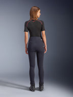 Alpinestars Stella Flex-AST Leggings in Schwarz, hoch taillierte Damen-Motorradhose, Rückansicht mit Skinny-Passform und Gesäßtaschen, getragen mit schwarzem Kurzarm-Oberteil und Motorradstiefeln, urbane Fahrausrüstung