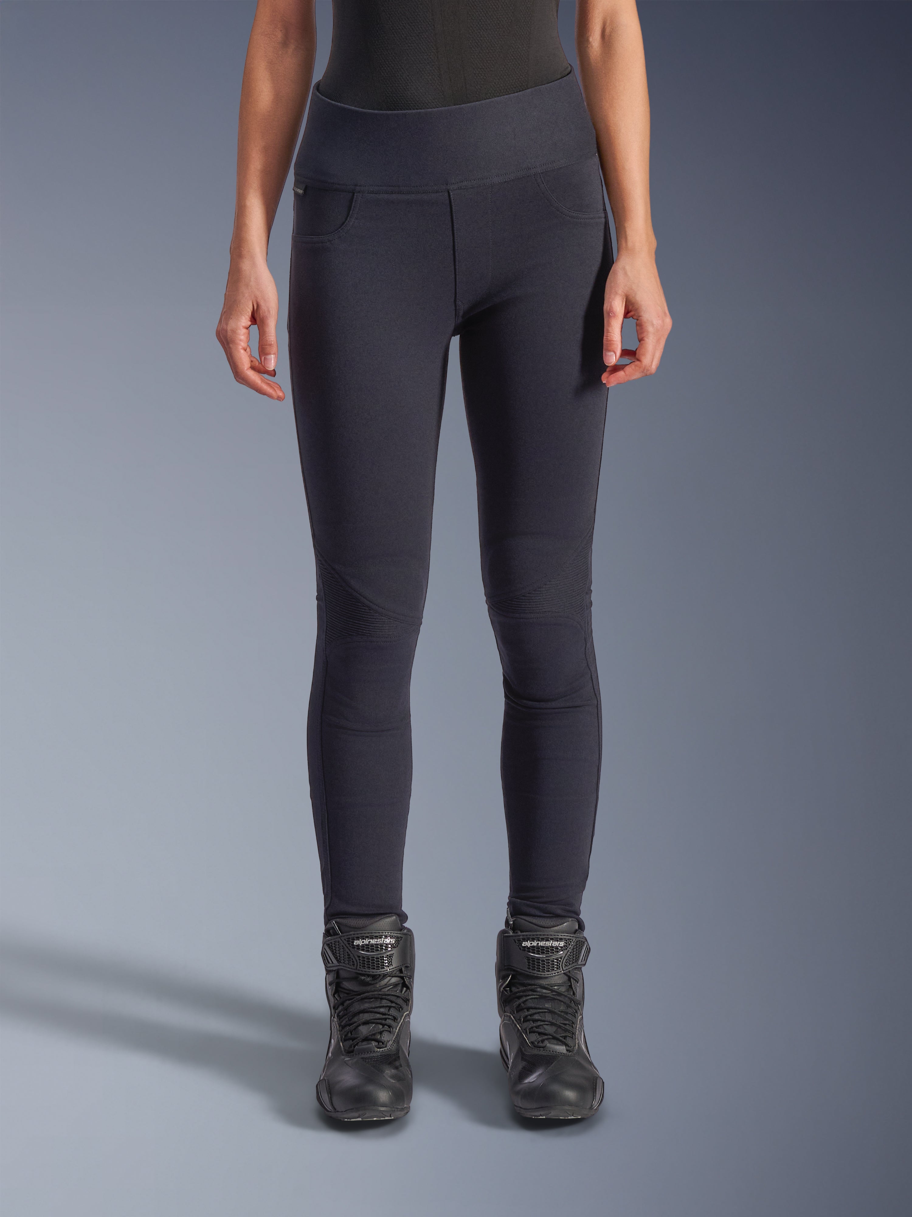 Alpinestars Stella Flex-AST Leggings für Damen - Short, Motorrad-Leggings für Damen in Schwarz, hoch taillierte Skinny-Passform mit Akkordeon-Knieeinsätzen, kombiniert mit schwarzen Alpinestars Motorradstiefeln, urbane Fahrausrüstung