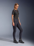 Alpinestars Stella Flex-Ast Leggings, Damen-Motorrad-Leggings in Schwarz, hoch tailliertes Slim-Fit-Design, getragen mit einem schwarzen T-Shirt mit roten Akzenten und schwarzen Fahrstiefeln, Studio-Ganzkörperaufnahme