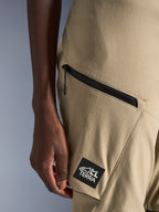 Alpinestars Stella Flex-AST Explorer Hose, Motorradhose für Damen, Sand, Detailaufnahme der Cargo-Tasche mit Reißverschluss und schwarzem ALL TERRA Logo-Aufnäher, strapazierfähige Ripstop-Textilkonstruktion für Adventure-Touren