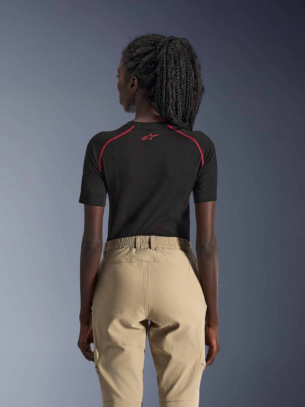 Alpinestars Stella Flex-AST Explorer Damen-Hose, Sand, Adventure-Motorradhose, Rückansicht getragen mit einem schwarzen, kurzärmeligen Baselayer mit roten Akzenten, elastischer Bund und strapazierfähige Textilkonstruktion