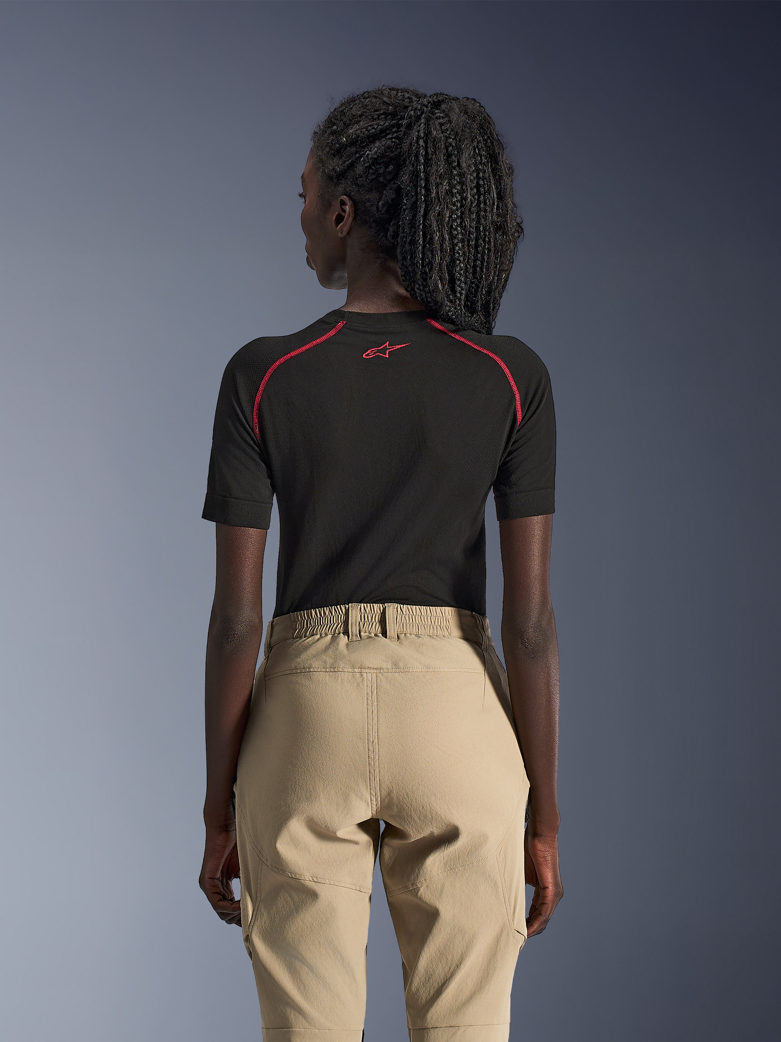 Alpinestars Stella Flex-AST Explorer Damen-Hose, Sand, Adventure-Motorradhose, Rückansicht getragen mit einem schwarzen, kurzärmeligen Baselayer mit roten Akzenten, elastischer Bund und strapazierfähige Textilkonstruktion