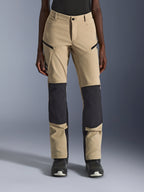 Alpinestars Stella Flex-AST Explorer Damen-Motorradhose, Aluminum Black, Frontansicht am Modell, sandfarbenes Textilgewebe mit markanten schwarzen Ripstop-Einsätzen an Knien und Unterschenkeln, Reißverschlusstaschen, Adventure-Touring-Stil