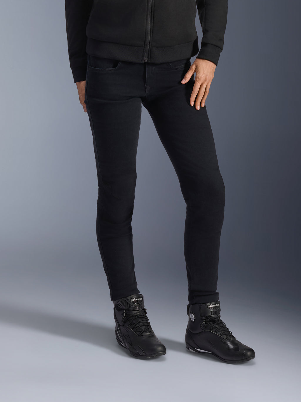 Alpinestars Daisy V3 Damen Motorrad-Jeans, Rinse Black, schmal geschnittene Motorradjeans, kombiniert mit schwarzen High-Top-Motorradstiefeln und Zip-Hoodie, elegantes monochromes Urban-Styling