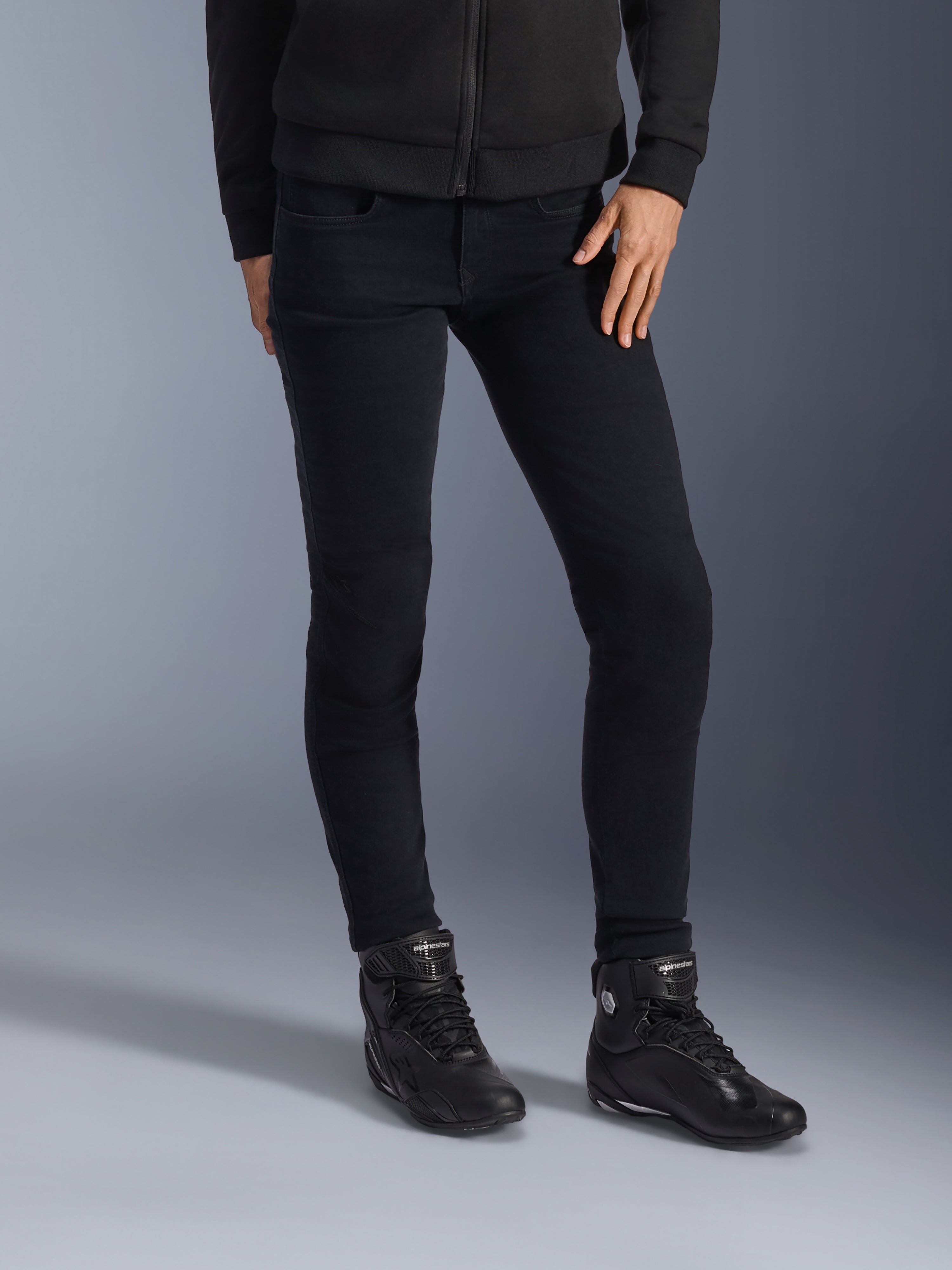 Alpinestars Daisy V3 Damen Motorrad-Jeans, Rinse Black, schmal geschnittene Motorradjeans, kombiniert mit schwarzen High-Top-Motorradstiefeln und Zip-Hoodie, elegantes monochromes Urban-Styling