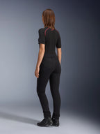Alpinestars Damen-Banshee Leggings, Schwarz, Rückansicht mit figurbetonter anatomischer Stretch-Passform und Gesäßtaschen, getragen mit schwarzem Kurzarm-Oberteil und Motorradstiefeln, elegante urbane Motorradausrüstung für Damen
