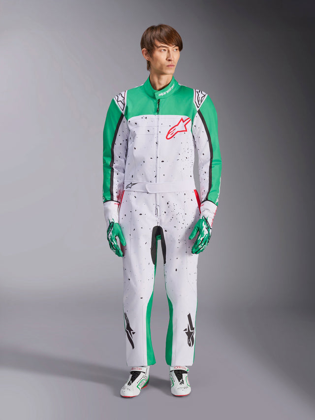 Alpinestars KMX-9 V3 Graphic 6 Suit, White Green and Red, one-piece karting suit featuring a black splatter graphic pattern, green panels on sleeves and legs, red Alpinestars chest logo, worn with matching racing gloves and shoes