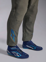Alpinestars GP Race V3 Anzug FIA, Autorennanzug in Anthrazit-Blau, Nahaufnahme der Unterschenkel mit einem blau bestickten Astars-Logo am Knöchel, kombiniert mit marineblauen und cyanfarbenen Rennstiefeln, professionelle Motorsport-Schutzausrüstung