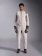 Alpinestars GP Race V3 Anzug FIA in Silber Anthrazit, einteiliger Autorennanzug, von einem Model getragen, mit dunkelgrauen Schulterklappen und Akzenten, kombiniert mit schwarzen Rennhandschuhen und Stiefeln, professionelle Motorsport-Schutzausrüstung