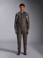 Alpinestars GP Race V3 Anzug FIA, Auto-Rennanzug, Schwarz und Silber, Vorderansicht eines Fahrers in vollständiger Rennausrüstung inklusive Handschuhen und Stiefeln, professionelles Motorsport-Design mit Alpinestars-Branding an den Schultern und am Gürtel