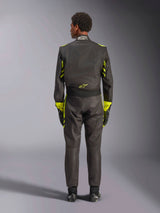 Alpinestars GP Race V3 Suit FIA, Rear view, Black with Yellow Fluo accents, featuring yellow panels on the arms and torso, yellow logo on the lower back, worn with matching racing gloves and boots, professional automotive racing suit.