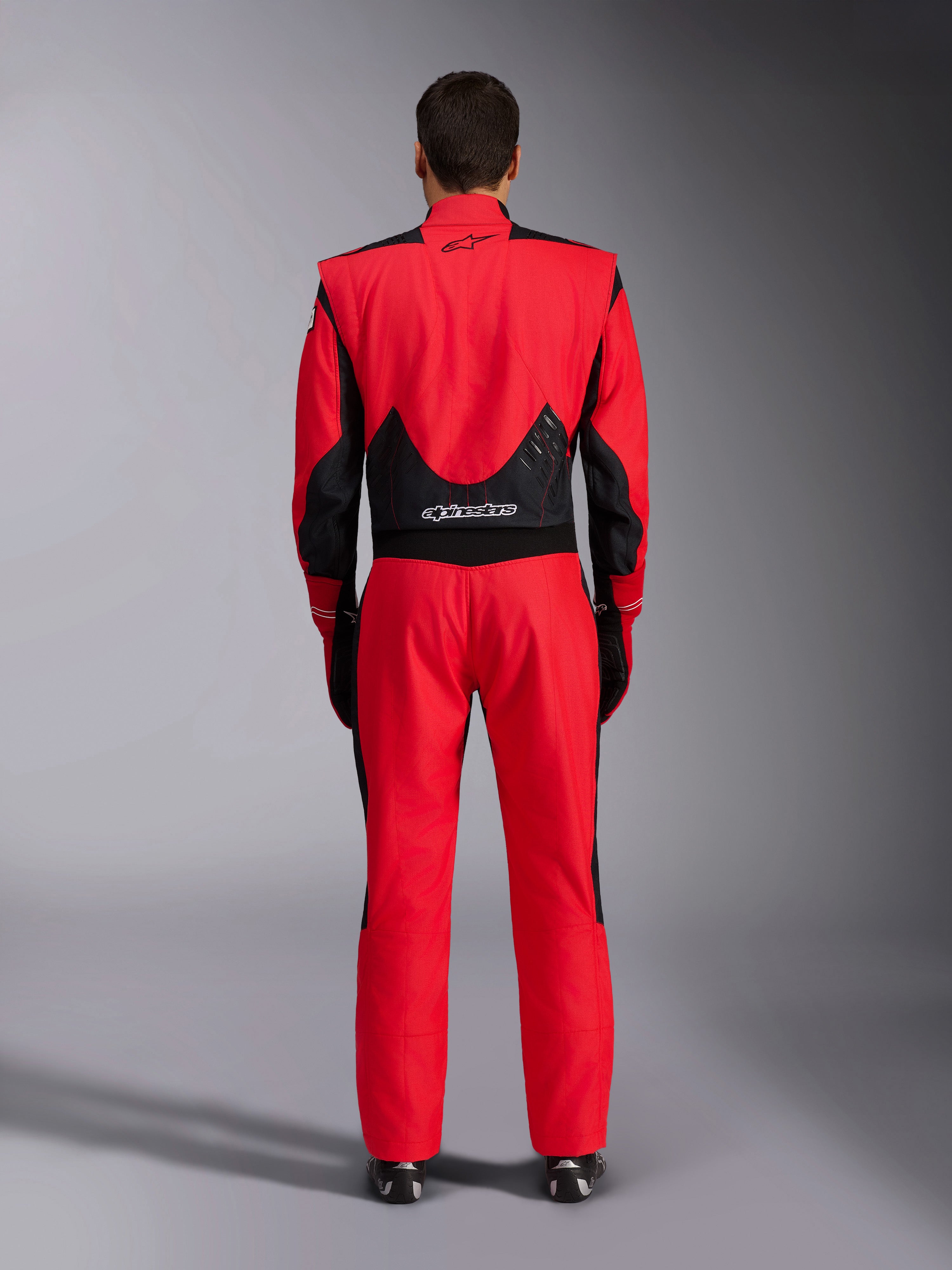 Alpinestars GP Pro Comp V2 FIA Rennanzug, Rot und Schwarz, Rückansicht mit schwarzen Mesh- und Stretcheinsätzen am unteren Rücken, Alpinestars-Branding am oberen und unteren Rücken, professionelle Motorsport-Ausrüstung