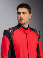 Männliches Model im Alpinestars GP Pro Comp V2 FIA Auto-Rennanzug, Rot und Schwarz, mit weißen Astars-Logos auf den Schultern und Silikon-Grip-Technologie-Details, professionelle Motorsportbekleidung