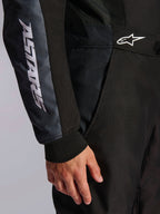 Alpinestars KMX-5 V3 Anzug, Kart-Anzug, Schwarz und Dark Shadow, Nahaufnahme von Hüfte und Arm, weißes ASTARS-Branding am Ärmel, weißes Logo an der Taille, Mesh-Einsätze zur Belüftung und gestricktes Ärmelbündchen