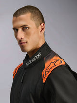 Alpinestars KMX-5 V3 Suit, Karting Suit, Black and Orange Fluo, close-up shot of the upper chest and collar worn by a model, featuring white Alpinestars branding on the neck and vibrant orange accents on the shoulders.