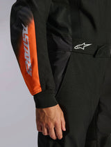 Alpinestars KMX-5 V3 Suit, Black White and Orange Fluo, close-up of torso and arm featuring ASTARS branding on the sleeve, white logo on waist, and breathable mesh panels