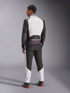Alpinestars KMX-5 V3 Anzug, Kart-Anzug, Weiß, Schwarz und leuchtendes Rot, Rückansicht eines Mannes in einem einteiligen Rennanzug mit weißem oberen Rücken und schwarzen Einsätzen, mit einem kleinen roten Logo am Kragen, getragen mit professionellen Rennstiefeln und Handschuhen