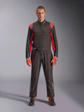 Alpinestars KMX-9 V3 Kart-Anzug, Schwarz und Fluo-Rot, einteiliger Rennanzug getragen mit farblich passenden Handschuhen und Stiefeln, mit leuchtend roten Schulterakzenten und Nähten, Alpinestars-Logo an den Unterschenkeln, schnittiges Motorsport-Design für den Rennsport