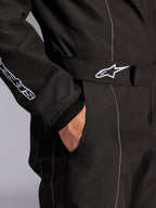 Alpinestars KMX-9 V3 Anzug, Schwarz-Weiß, Nahaufnahme des verstellbaren Taillengürtels mit besticktem Logo, Seitentasche, weiße Kontrastnähte auf schwarzem Stoff, technisches Detail des Karting-Anzugs