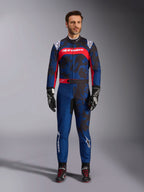 Alpinestars KMX-9 V3 Graphic 5 Anzug, Kart-Anzug in Navy-Blau und Rot, mit einem abstrakten grafischen Muster im Camouflage-Stil, getragen von einem Modell mit schwarzen Rennhandschuhen und Schuhen, sportliches Design mit markantem Alpinestars-Branding auf der Brust und den Beinen.