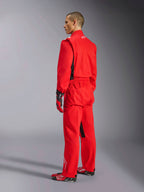Alpinestars Kart Indoor V2 Anzug, roter Kart-Anzug, Dreiviertel-Rückansicht an einem Modell, getragen mit passenden roten Handschuhen und Rennschuhen, einlagige Poly-Baumwoll-Twill-Konstruktion, professionelle Motorsportausrüstung für Indoor-Kartfahren.