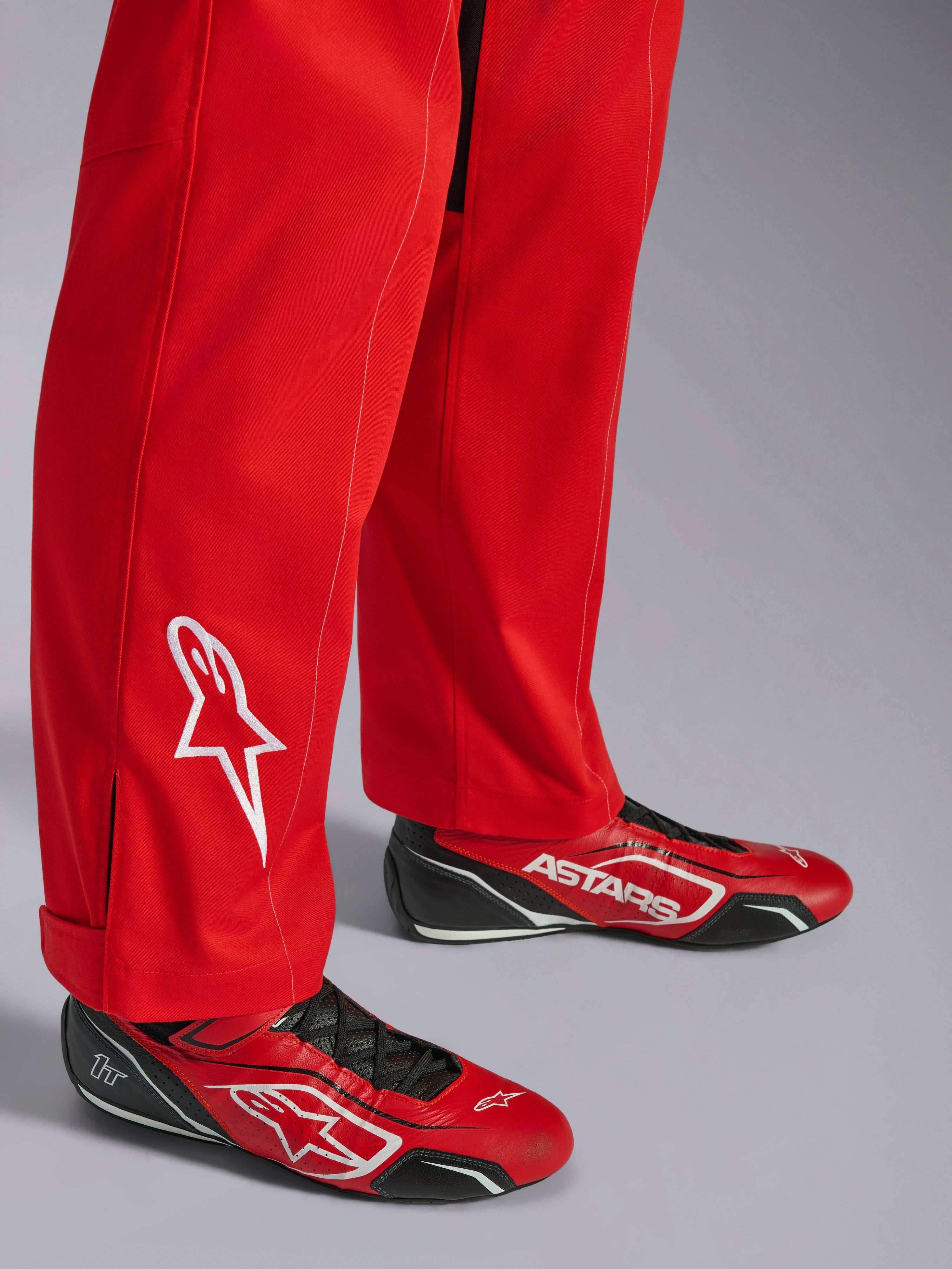 Alpinestars Kart Indoor V2 Anzug, Rot, Unterschenkel-Detail mit weiß gesticktem Stern-Logo, kombiniert mit passenden rot-schwarzen Kartschuhen, einlagiges Poly-Baumwoll-Twill-Material für den Freizeit-Rennsport