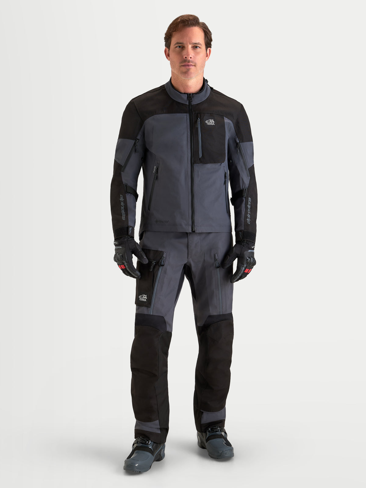 Alpinestars Arenis Gore-Tex® Gear Set, Herren-Adventure-Motorradkombi in Schwarz und Dunkelgrau, Vorderansicht des Models in wasserdichter All-Terrain-Schutzausrüstung