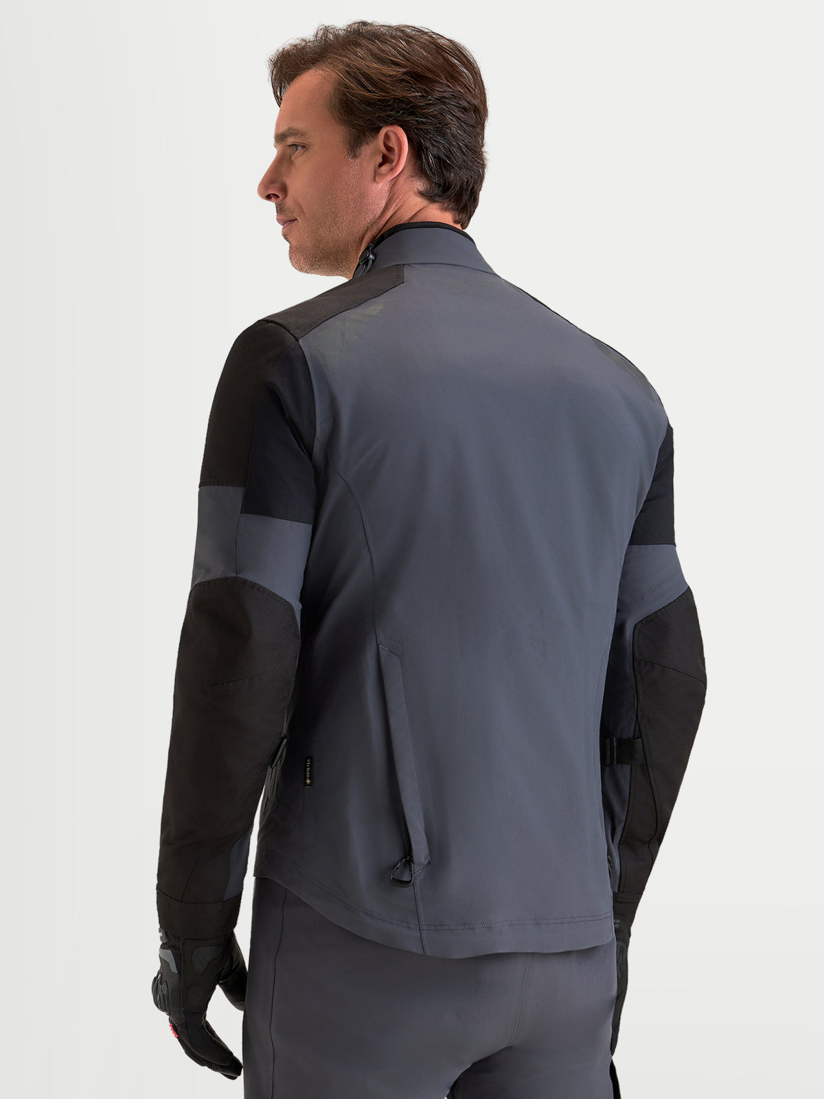 Alpinestars Arenis Gore-Tex Jacke, Herren-Adventure-Motorradjacke in Schwarz und Dunkelgrau, Rückansicht des Modells mit wasserdichter Textilkonstruktion und ergonomischem Kragen