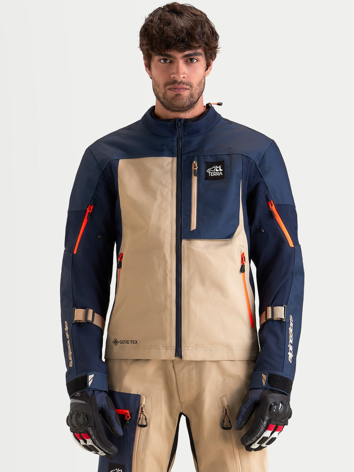 Alpinestars Arenis Gore Tex Jacke, Herren-Adventure-Motorradjacke in Nachtblau und Aluminium, Vorderansicht an einem Model mit passender Ausrüstung und Handschuhen, wasserdichte Textilkonstruktion mit GORE-TEX