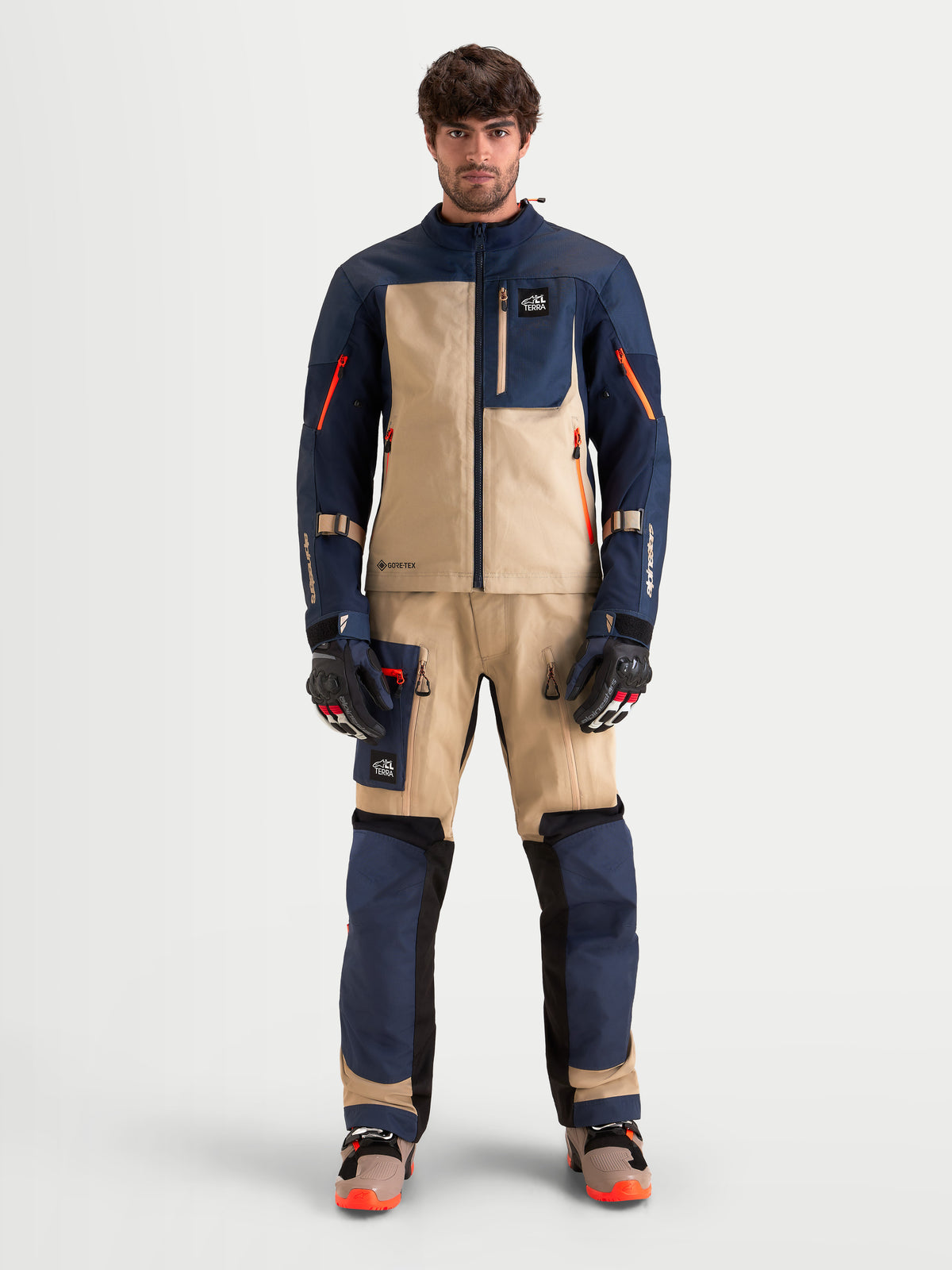 Alpinestars Arenis Gore-Tex® Gear Set, Herren-Abenteuer-Motorradkombi in Nachtblau und Aluminium, Vorderansicht an einem Model mit passender technischer Schutzausrüstung und Handschuhen