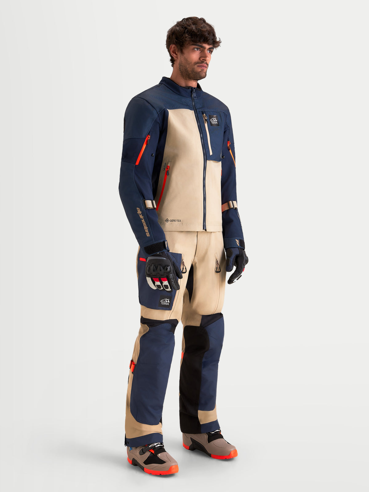 Alpinestars Arenis Gore-Tex Gear Set, Herren-Abenteuer-Motorradkombi in Nachtblau und Aluminium, Studio-Ansicht von vorn an einem Model in passender Schutzausrüstung und Stiefeln