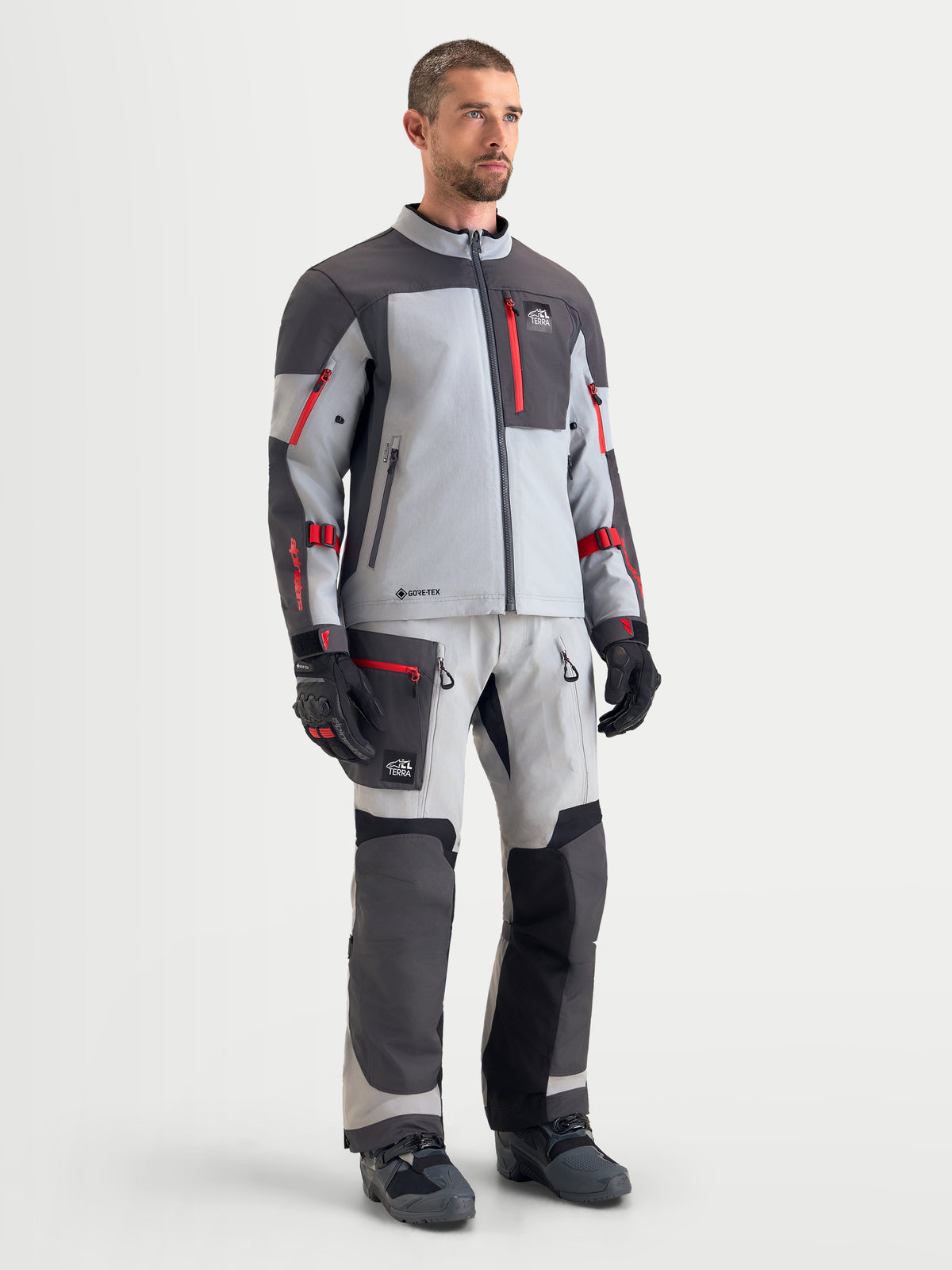 Alpinestars Arenis Gore-Tex Jacke, Herren-Adventure-Motorradjacke in Mittelgrau, Dunkelgrau und Schwarz, getragen von einem männlichen Model, mit wasserdichter Textilkonstruktion und passender Fahrerausrüstung
