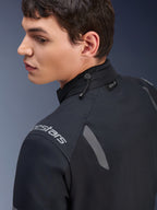 Alpinestars ST-7 2L GORE-TEX Jacke, Motorradjacke in Schwarz und Dunkelgrau, Nahaufnahme des Kragens mit Kordelzugverstellung und Tech-Air-Label, mit grauen reflektierenden Akzenten und Markenlogo auf der Schulter.