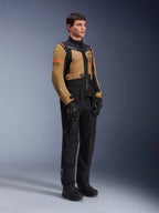 Alpinestars ST-7 2L GORE-TEX Jacke, Motorradjacke, Gobi-Braun und Schwarz, getragen von einem Model mit passender schwarzer Hose und Handschuhen, mit braunen Einsätzen an Brust und Ärmeln, schwarzen technischen Akzenten und orangefarbenem Branding, Adventure-Touring-Motorradausrüstung.
