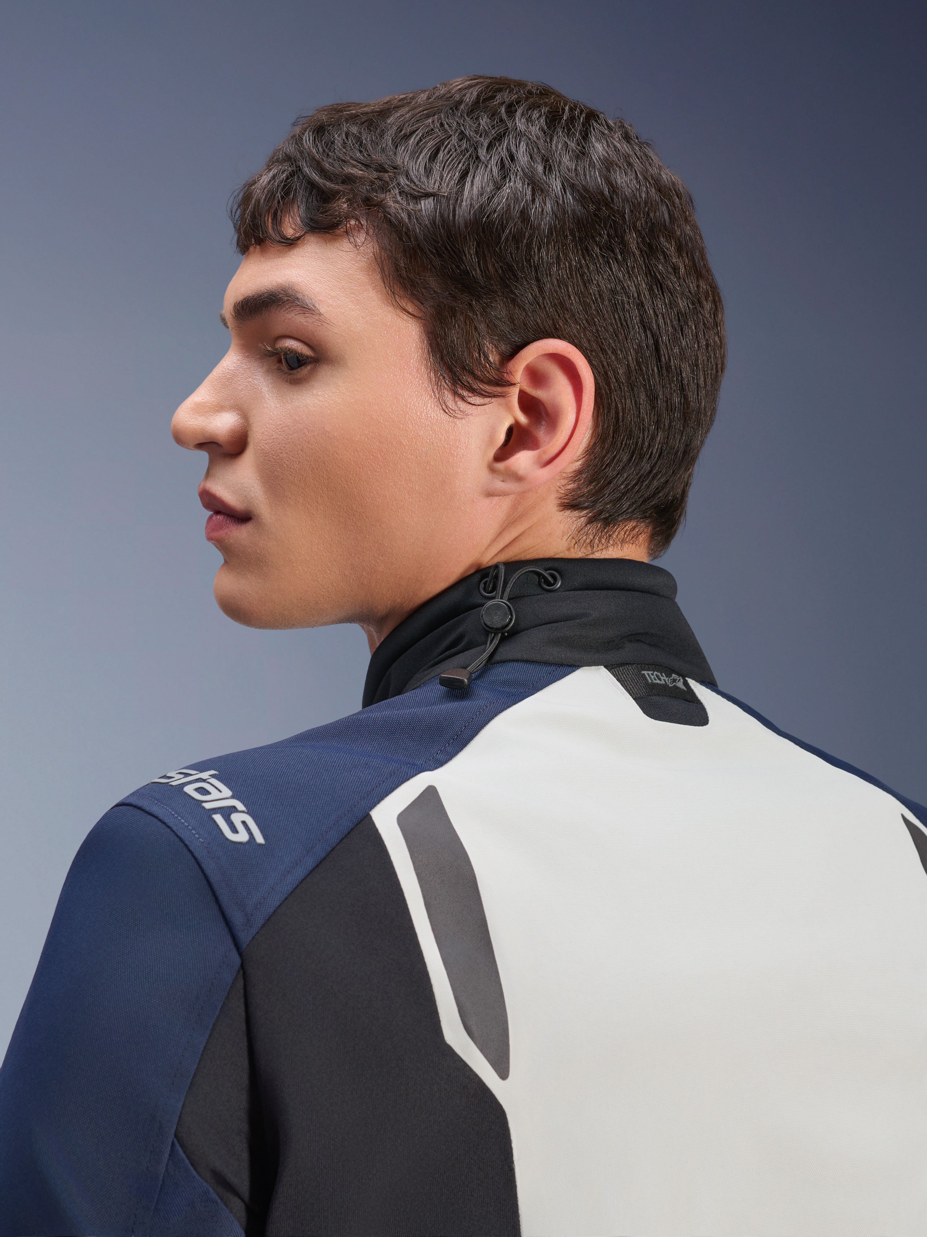 Alpinestars ST-7 2L GORE-TEX Jacke, Nahaufnahme der Profilansicht von Rücken- und Nackenbereich, Ice Gray, Dunkelblau und Schwarz, mit verstellbarem Kordelzug am Kragen und Tech-Air-Branding, erstklassige Adventure-Touring-Motorradjacke.
