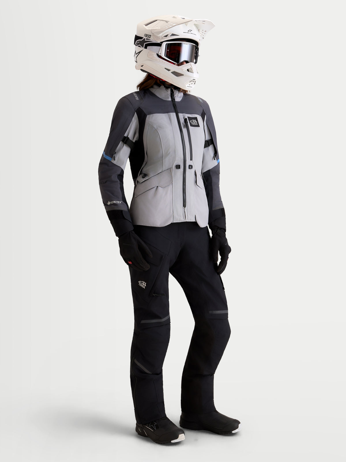 Alpinestars Stella St-7 V2 2L Gore-Tex® Jacket, women's adventure touring motorcycle jacket in mid gray, deep gray, and black, front studio view on a model wearing matching pants, gloves, and helmet, AA certified waterproof all-terrain riding apparel.
