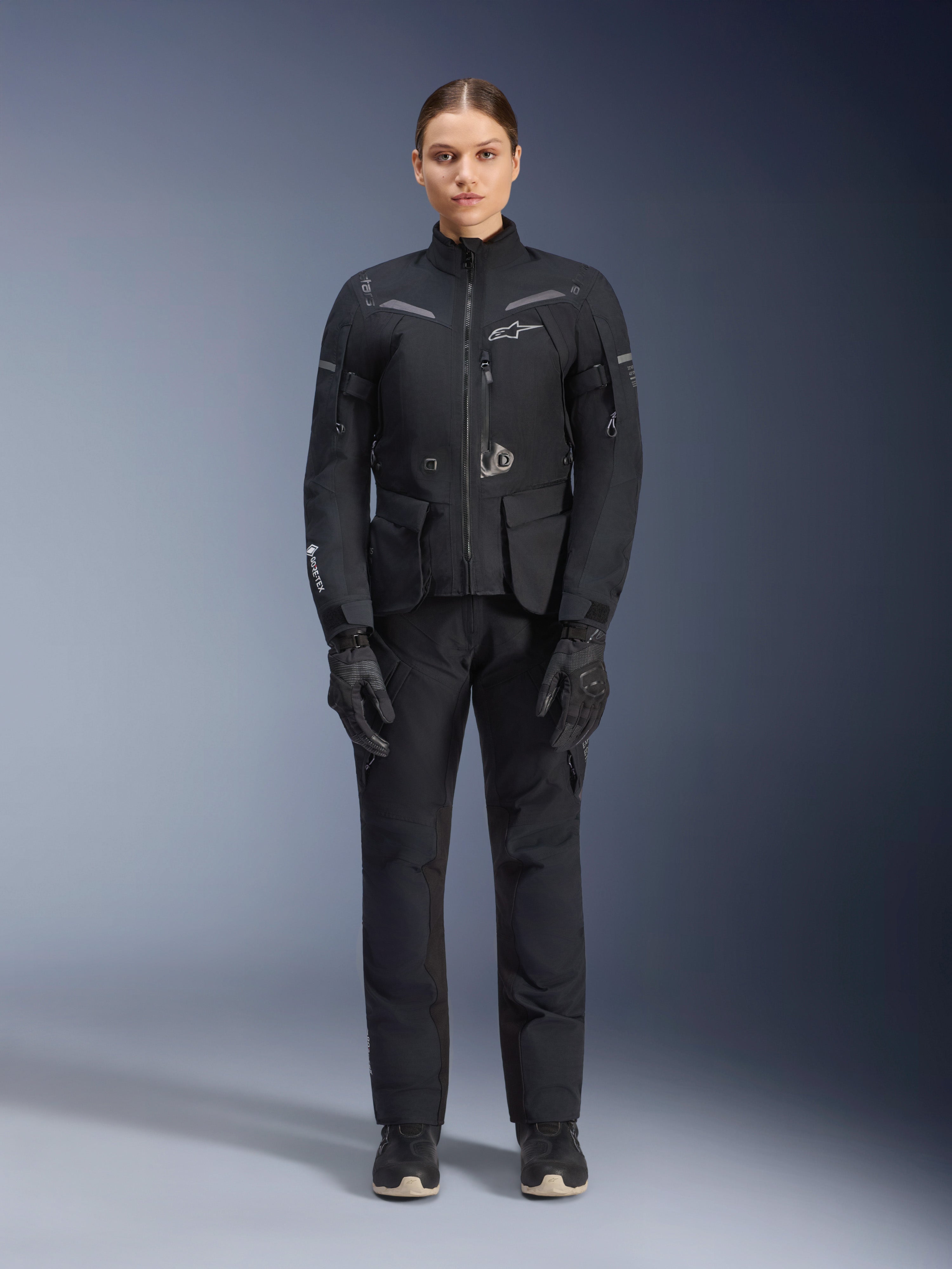 Alpinestars Stella ST-7 2L GORE-TEX Jacke, Motorrad-Tourenjacke für Damen, Schwarz und Dunkelgrau, getragen mit passender Fahrhose und Handschuhen, mit wasserdichter laminierter Außenhülle, reflektierenden Akzenten und ergonomischem Adventure-Design