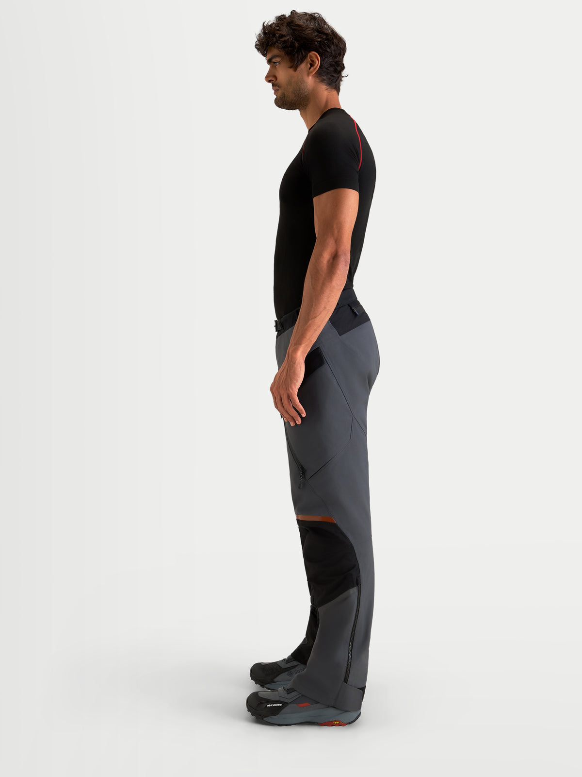 Alpinestars St-7 V2 2L Gore-Tex Pants, men's adventure touring motorcycle pants in deep gray and black, side profile view on a model showing waterproof textile construction and ergonomic knee panels