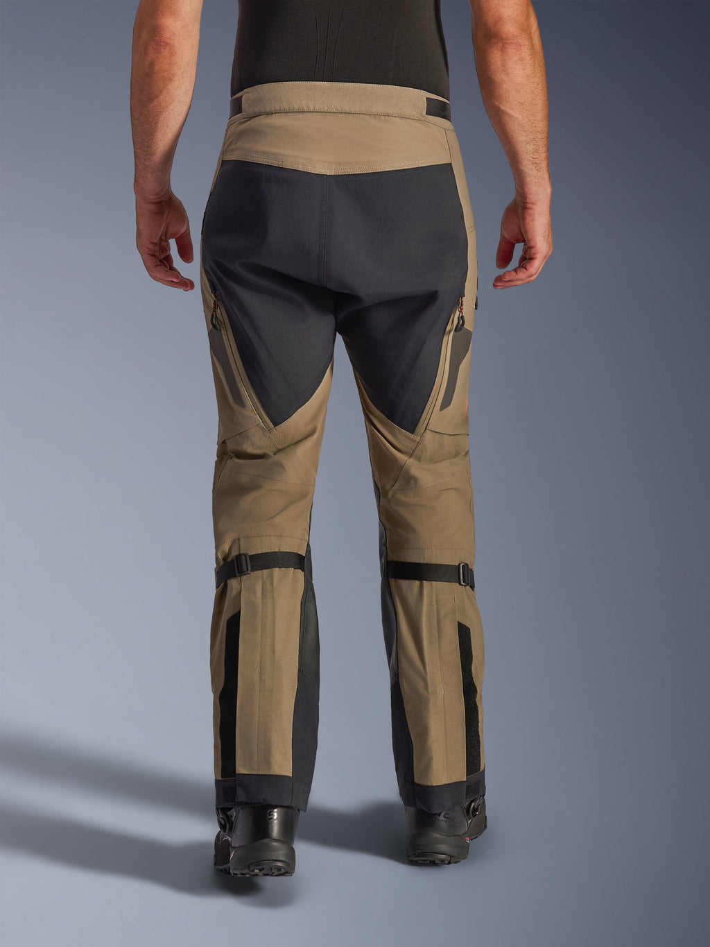 Alpinestars Nazca 3L GORE-TEX PRO Hose, Walnuss und Schwarz, Rückansicht mit Wadenvolumenverstellern und verstärkten Einsätzen, technische Adventure-Motorradhose für Fahrten bei jedem Wetter